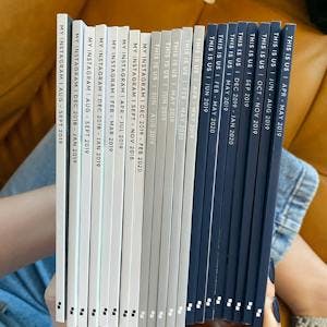 Woman holding collection of photo books showing off their spines